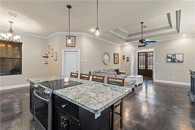 kitchen featuring a kitchen bar, hanging light fixtures, a center island, electric range, and a tray ceiling