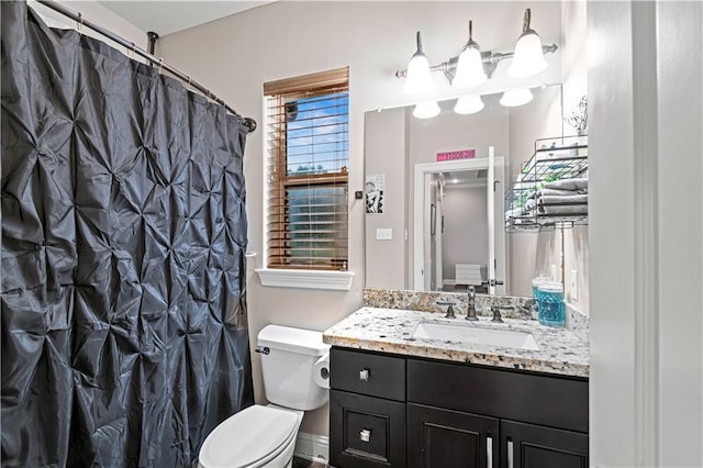 bathroom featuring vanity, a shower with shower curtain, and toilet