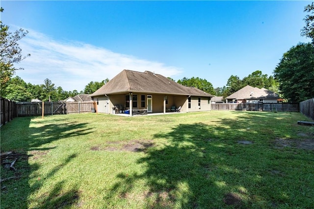 rear view of property with a lawn and a patio area