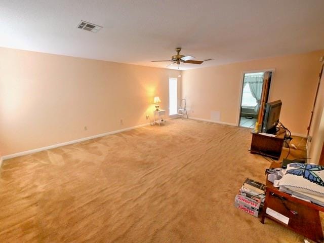 interior space featuring light colored carpet and ceiling fan