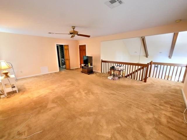 interior space with ceiling fan, beam ceiling, and carpet floors