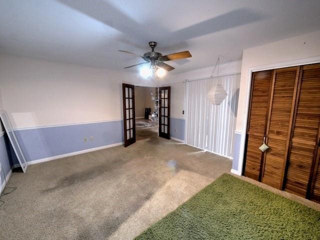 unfurnished bedroom with carpet floors, french doors, ceiling fan, and a closet