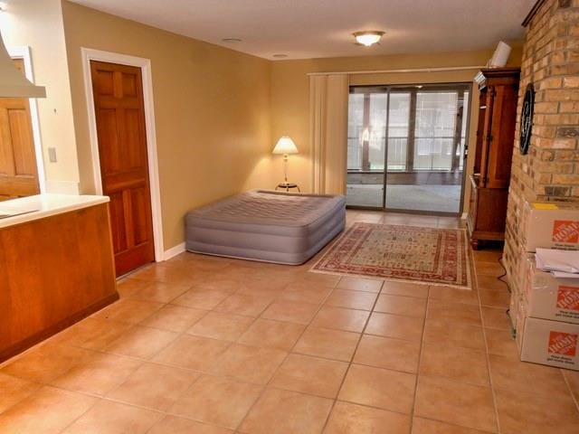 unfurnished living room with brick wall and light tile patterned floors