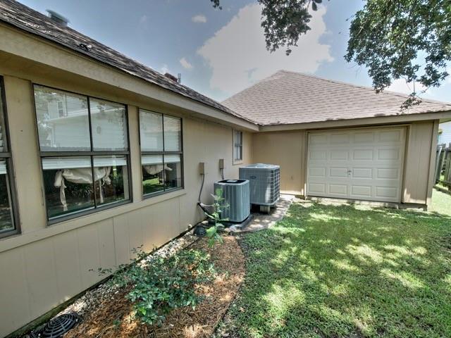 view of home's exterior featuring central AC unit, a garage, and a yard