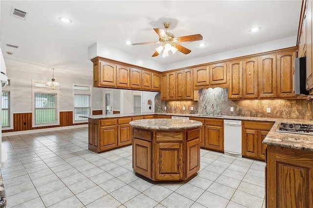 kitchen with backsplash, a center island, white dishwasher, stainless steel gas stovetop, and ceiling fan