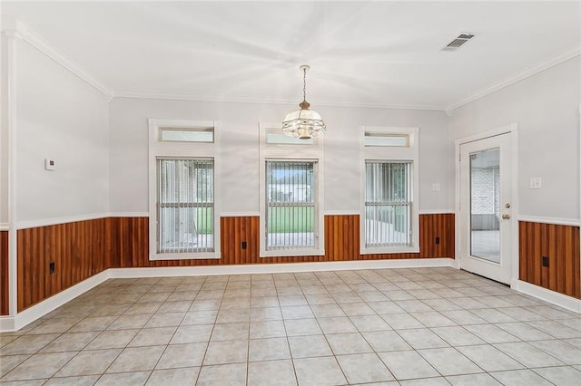 empty room with crown molding, a chandelier, and light tile patterned floors