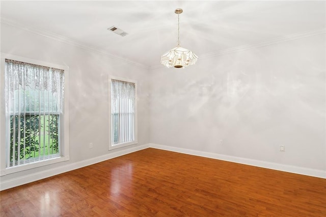 unfurnished room with wood-type flooring, ornamental molding, and a chandelier