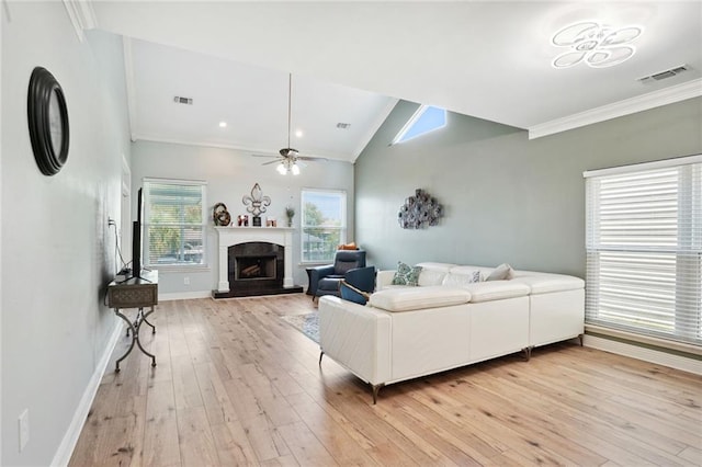 living room featuring light wood-type flooring, lofted ceiling, ornamental molding, and ceiling fan