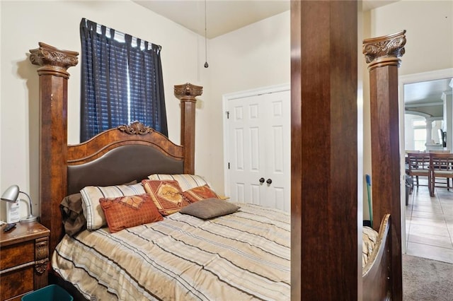 tiled bedroom with a closet and decorative columns