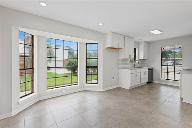 kitchen featuring a healthy amount of sunlight, light tile patterned floors, and white cabinets