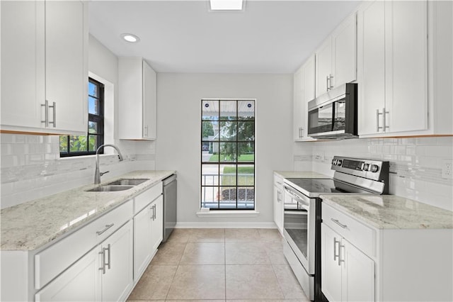 kitchen with appliances with stainless steel finishes, decorative backsplash, white cabinetry, sink, and plenty of natural light