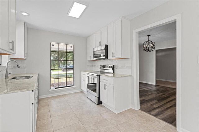 kitchen featuring sink, light hardwood / wood-style flooring, decorative backsplash, electric stove, and white cabinets