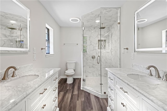 bathroom with toilet, a shower with door, vanity, and wood-type flooring