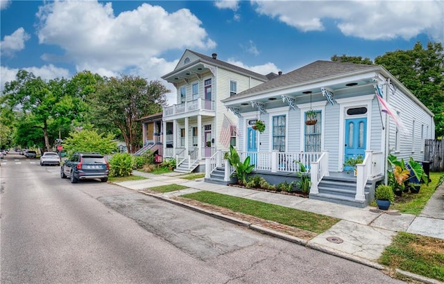 italianate-style house featuring a balcony and covered porch