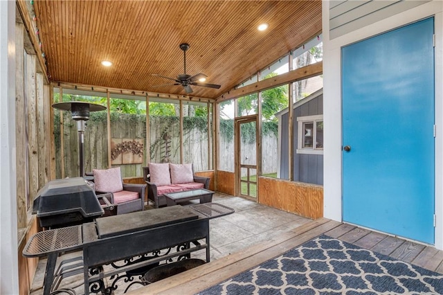 sunroom with ceiling fan, lofted ceiling, wooden ceiling, and a healthy amount of sunlight