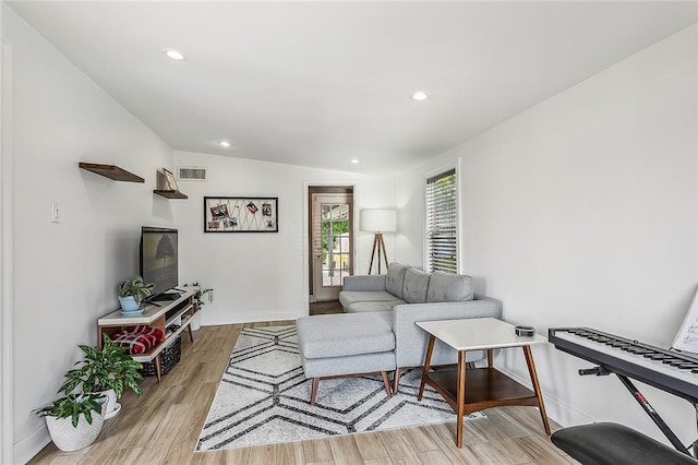 living room with vaulted ceiling and light wood-type flooring