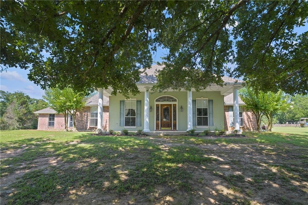 view of front facade with a front yard and covered porch