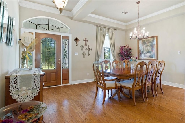 dining room featuring an inviting chandelier, crown molding, and light hardwood / wood-style floors