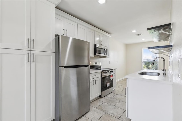 kitchen featuring white cabinetry, sink, stainless steel appliances, and light tile patterned floors