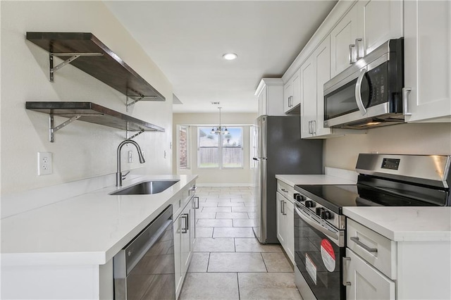 kitchen featuring white cabinets, range, dishwasher, light tile patterned floors, and sink