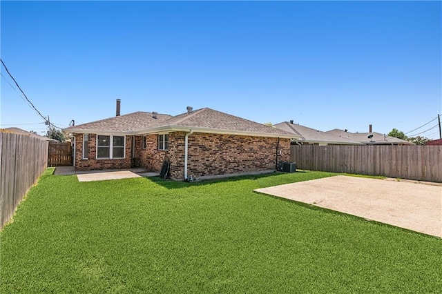 back of property with central AC unit, a patio, and a lawn