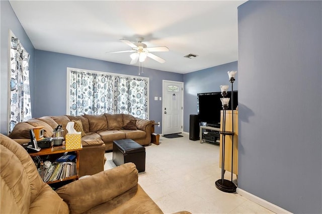 living room featuring ceiling fan, plenty of natural light, and light tile patterned flooring