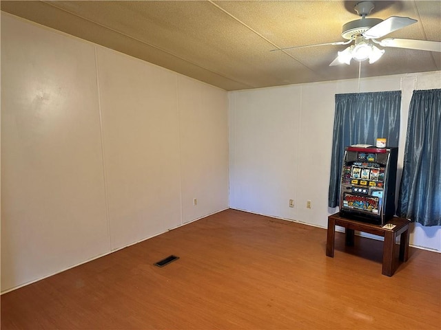 spare room featuring a textured ceiling, wood-type flooring, and ceiling fan