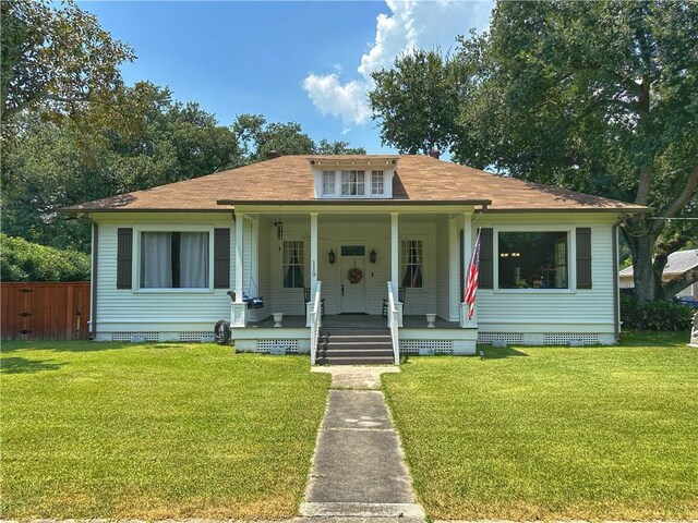 bungalow-style home with covered porch and a front yard