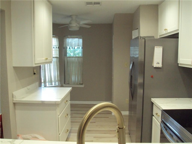 kitchen with ceiling fan, white cabinets, kitchen peninsula, and light stone counters