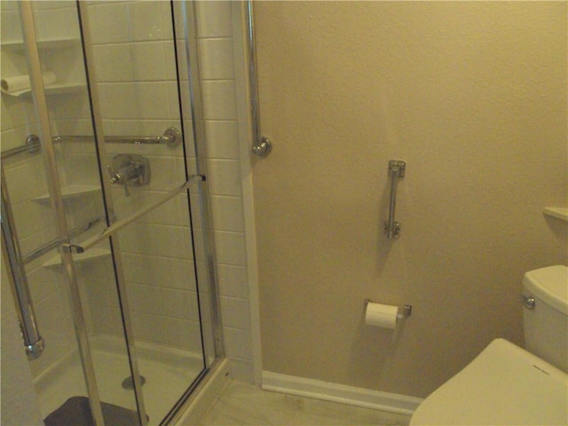 bathroom with toilet and an enclosed shower