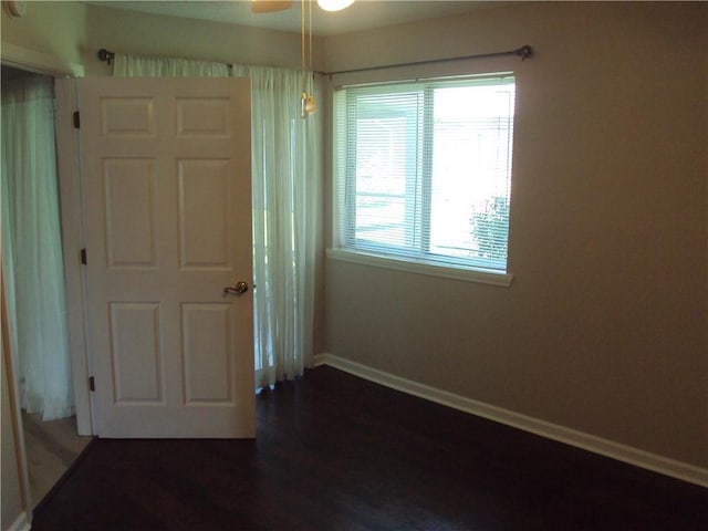 unfurnished bedroom with ceiling fan, wood-type flooring, and multiple windows