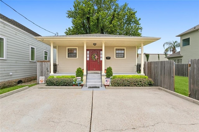 view of front facade featuring a porch, fence, and central AC unit