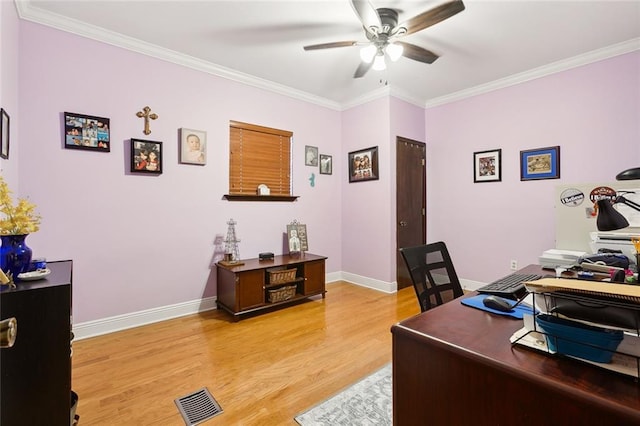 office space featuring ornamental molding, light wood finished floors, visible vents, and a ceiling fan