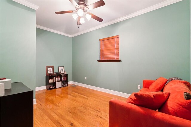 living area featuring baseboards, visible vents, ceiling fan, ornamental molding, and wood finished floors