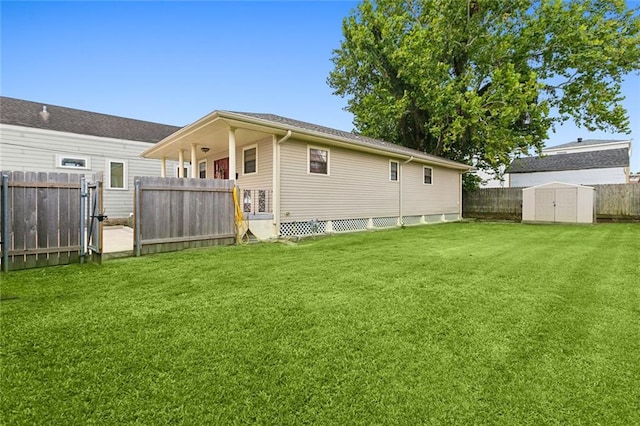 rear view of property featuring a yard, a shed, a fenced backyard, and an outbuilding