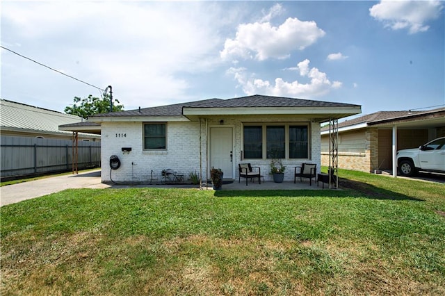 exterior space with a carport and a lawn