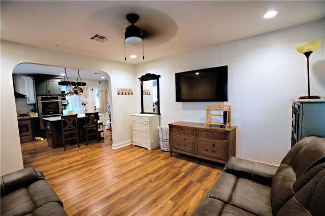 living room featuring ceiling fan and hardwood / wood-style floors