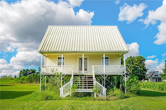 back of property featuring a porch and a yard