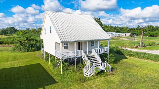 back of house featuring a lawn and a porch