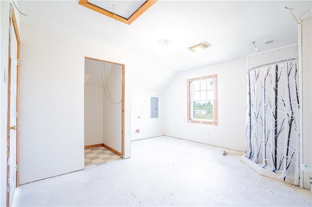 interior space with electric panel, visible vents, lofted ceiling, and attic access