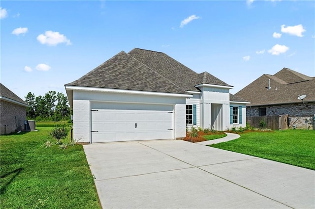 view of front of home with a front lawn, a garage, and central AC unit