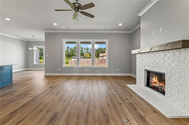 unfurnished living room with hardwood / wood-style floors, ceiling fan with notable chandelier, and crown molding