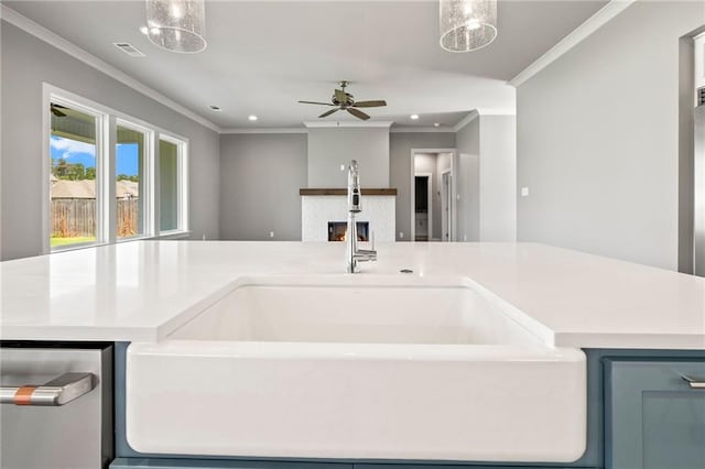 kitchen with blue cabinetry, ceiling fan with notable chandelier, crown molding, and sink