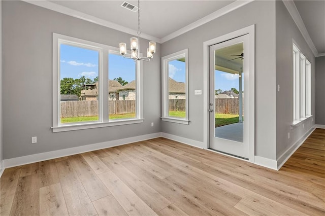 unfurnished dining area with crown molding, light hardwood / wood-style floors, and a notable chandelier