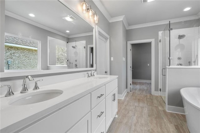 bathroom featuring crown molding, vanity, wood-type flooring, and plus walk in shower