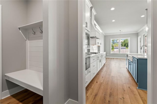 mudroom with ornamental molding and light hardwood / wood-style floors