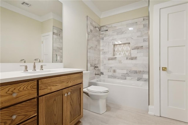 full bathroom featuring wood-type flooring, ornamental molding, vanity, tiled shower / bath, and toilet