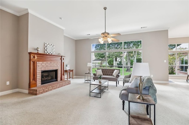 carpeted living room with ceiling fan, ornamental molding, and a brick fireplace