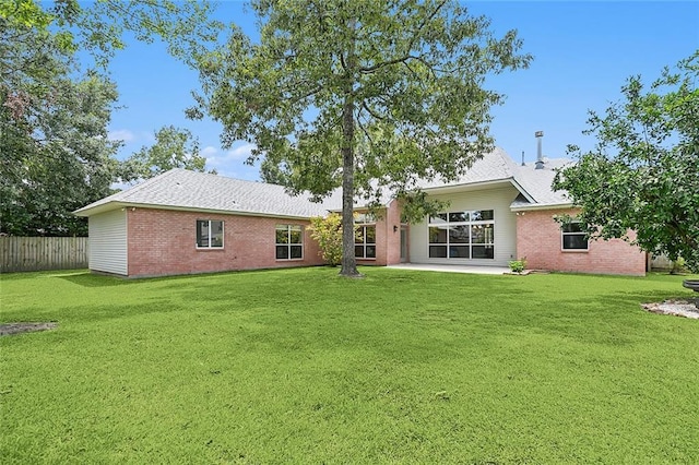 rear view of house with a lawn and a patio