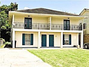 rear view of house with a balcony and a lawn